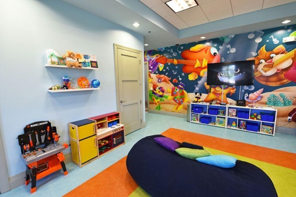 A colorful children's playroom features a mural, toy workbench, storage cubbies, and a beanbag chair — 1551 OBSERVER LANE, DAVENPORT, FL