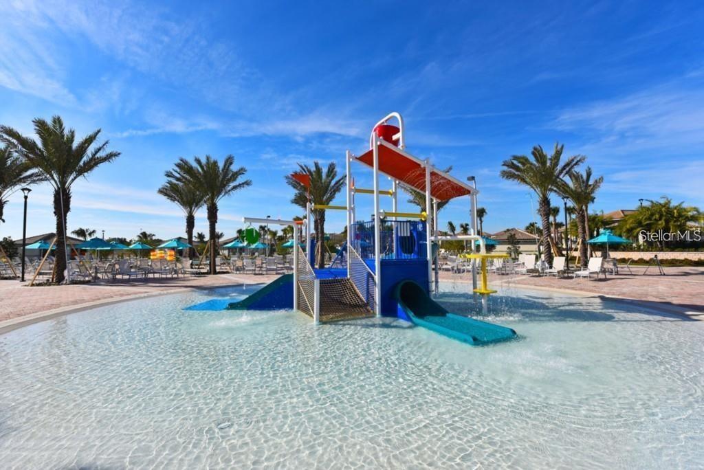 A shallow swimming pool features a colorful children's play structure with slides and palm trees — 1551 OBSERVER LANE, DAVENPORT, FL