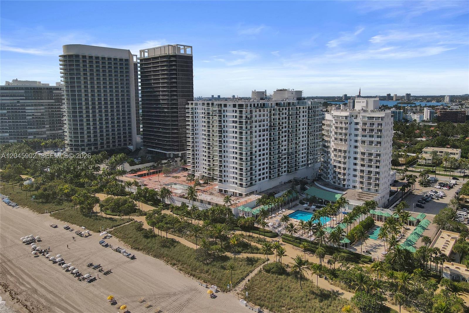 An aerial view shows several high-rise residential buildings situated along a sandy beach — 9801 Collins Ave # 8S, Bal Harbour FL 33154, BAL HARBOUR, FL
