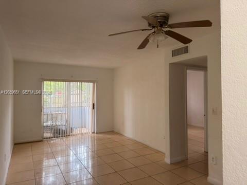 A living room with light-colored tile flooring, a ceiling fan, and sliding glass balcony doors — 2400 NW 22nd Ct # 3, Miami FL 33142, MIAMI, FL