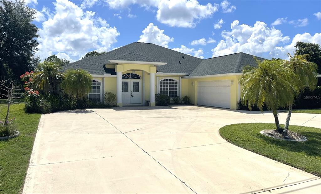 A yellow single-story house with a white double door, columns, and a concrete driveway — 2244 MAURITANIA ROAD, PUNTA GORDA, FL