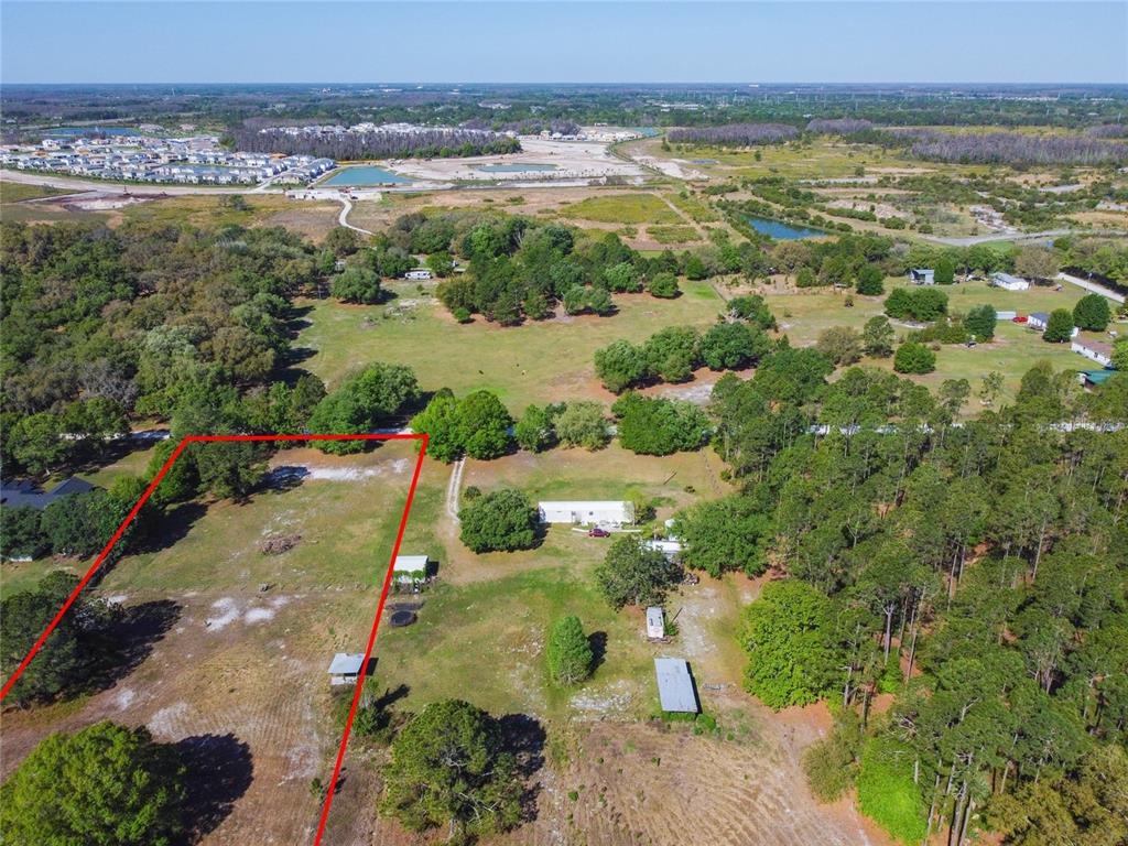 An aerial view shows a large, grassy lot outlined in red with several small structures — TINA MARIE DRIVE, ZEPHYRHILLS, FL