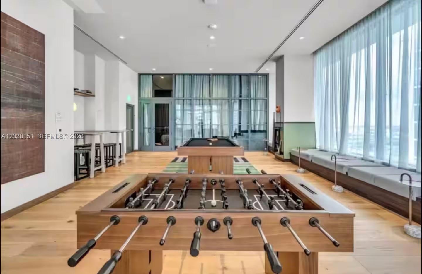 A game room featuring a foosball table, a pool table, and floor-to-ceiling windows — 11 NE 6th St # 1212, Miami FL 33132, MIAMI, FL