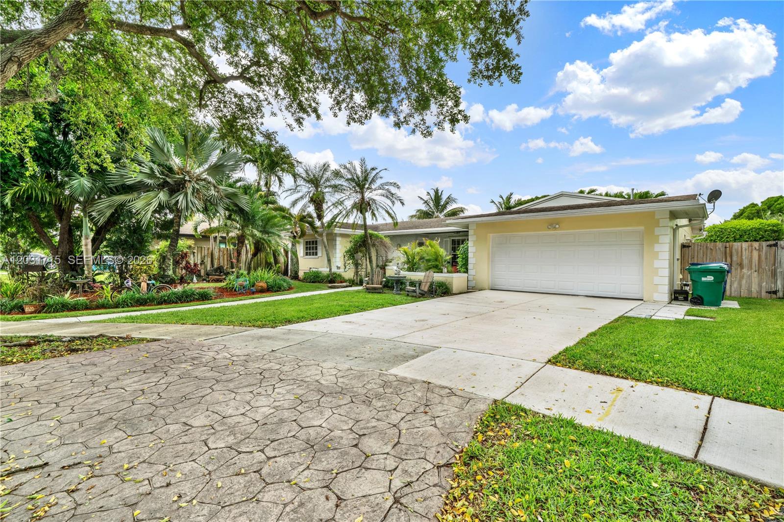 A single-story house with a white garage, a concrete driveway, and lush landscaping — 18920 SW 92nd Ct, Cutler Bay FL 33157, CUTLER BAY, FL