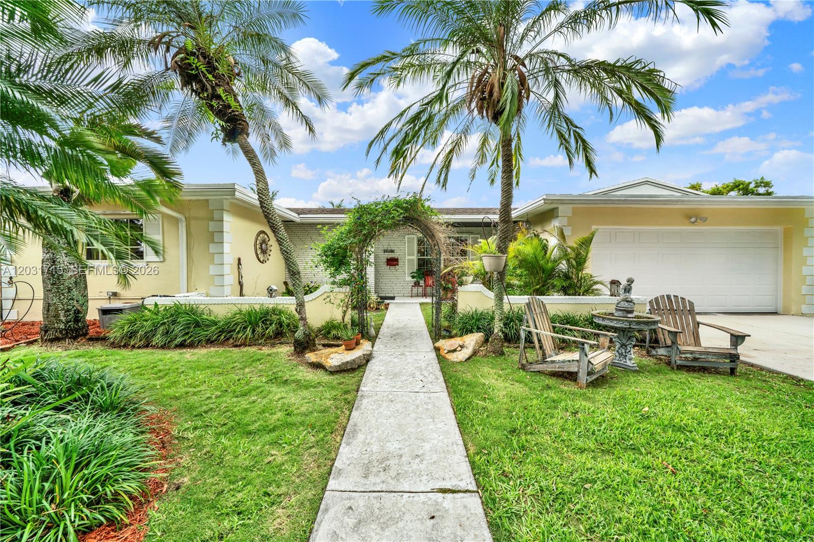 A single-story house features a concrete walkway, a metal arbor, and two palm trees — 18920 SW 92nd Ct, Cutler Bay FL 33157, CUTLER BAY, FL