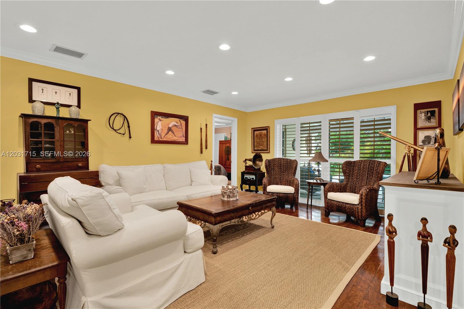 A living room features yellow walls, white sofas, wicker chairs, and a wooden coffee table — 18920 SW 92nd Ct, Cutler Bay FL 33157, CUTLER BAY, FL