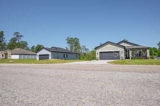 Three modern single-family homes sit along a paved road under a clear blue sky — 602 MARION OAKS LANE, OCALA, FL