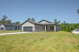 A single-story suburban house with a gray exterior and a two-car garage — 602 MARION OAKS LANE, OCALA, FL