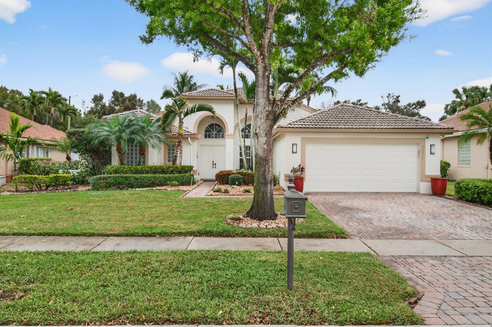 A single-story house with a white stucco facade, tiled roof, and a brick-paved driveway — 11511 Pamplona Boulevard, Boynton Beach FL 33437, BOYNTON BEACH, FL