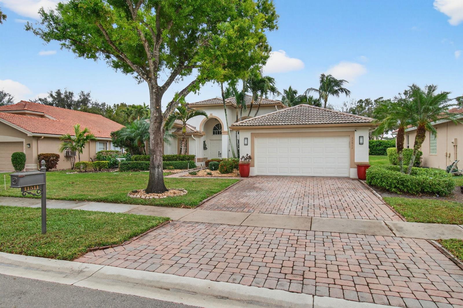 A single-story house with a brick paver driveway, a two-car garage, and a large tree — 11511 Pamplona Boulevard, Boynton Beach FL 33437, BOYNTON BEACH, FL