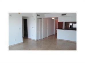 An interior view of a room with light-colored tile flooring and a kitchen breakfast bar — 31 SE 5th Street # 3207, Miami FL 33131, MIAMI, FL