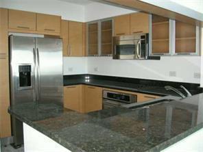 A kitchen features light wood cabinets, dark granite countertops, and stainless steel appliances — 31 SE 5th Street # 3207, Miami FL 33131, MIAMI, FL