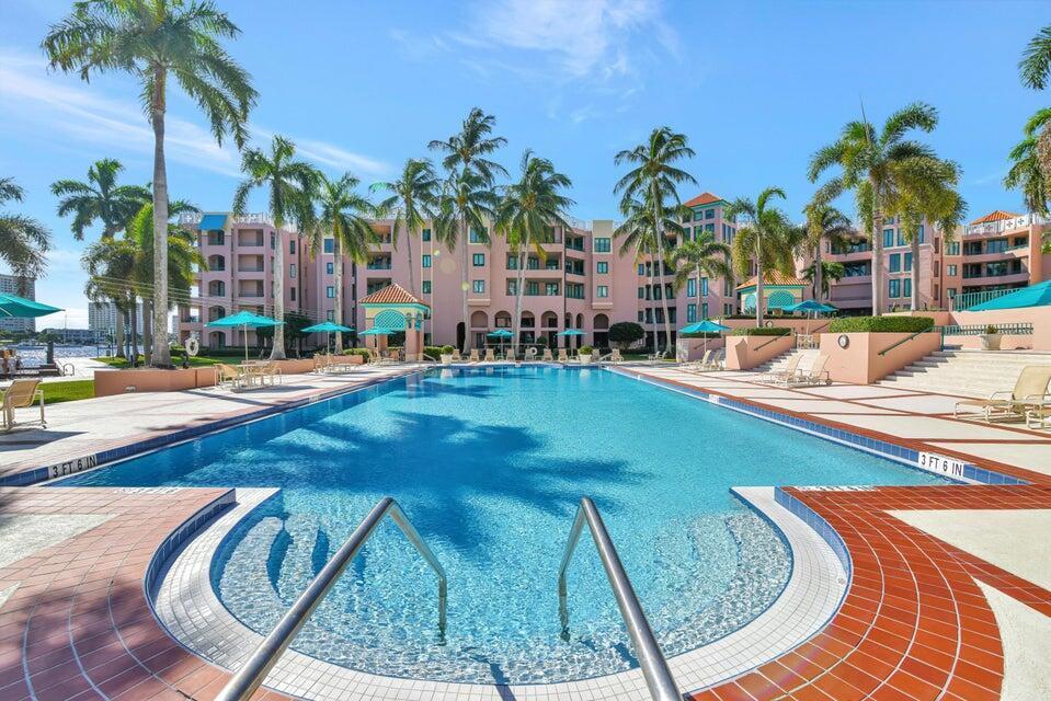 A large outdoor swimming pool is surrounded by a tiled deck and palm trees — 100 SE 5th Avenue # 107, Boca Raton FL 33432, BOCA RATON, FL