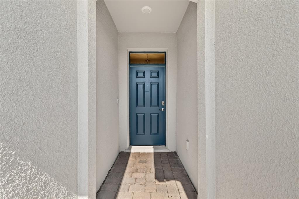 A blue front door is set within a recessed entryway with light-colored stucco walls — 1558 TISBURY PT, SANFORD, FL