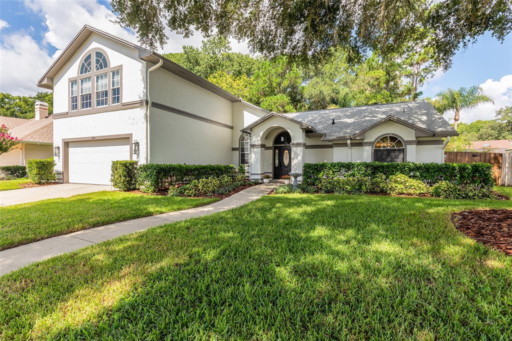 A two-story house with a white stucco exterior, a front-facing garage, and a landscaped yard — 804 SILVERWOOD DRIVE, LAKE MARY, FL