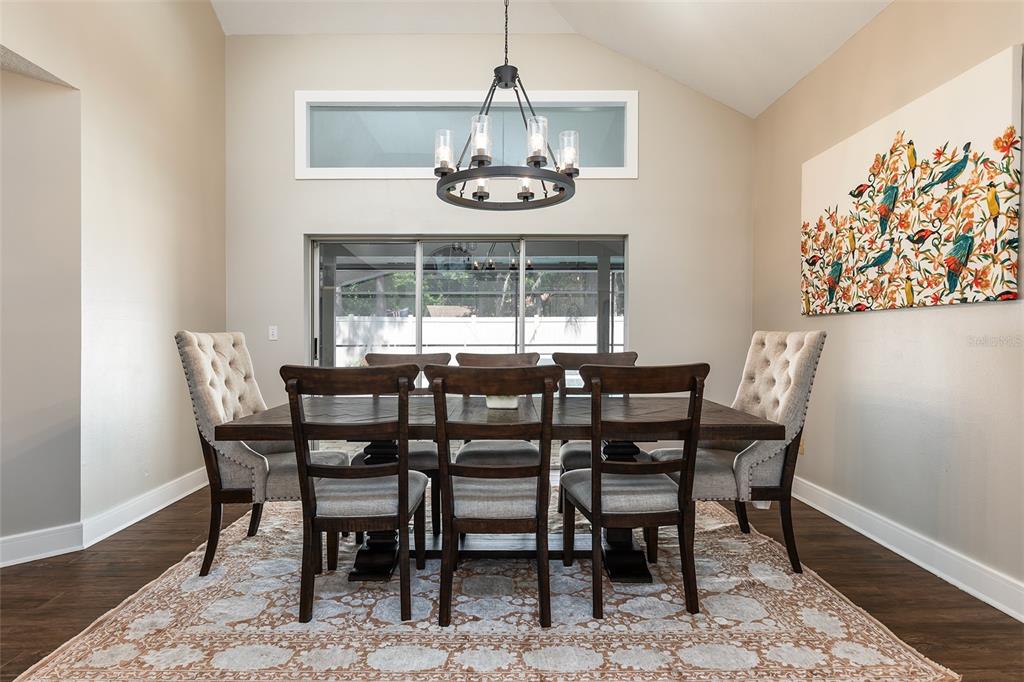 A dining room features a wooden table, six chairs, a chandelier, and wall art — 804 SILVERWOOD DRIVE, LAKE MARY, FL