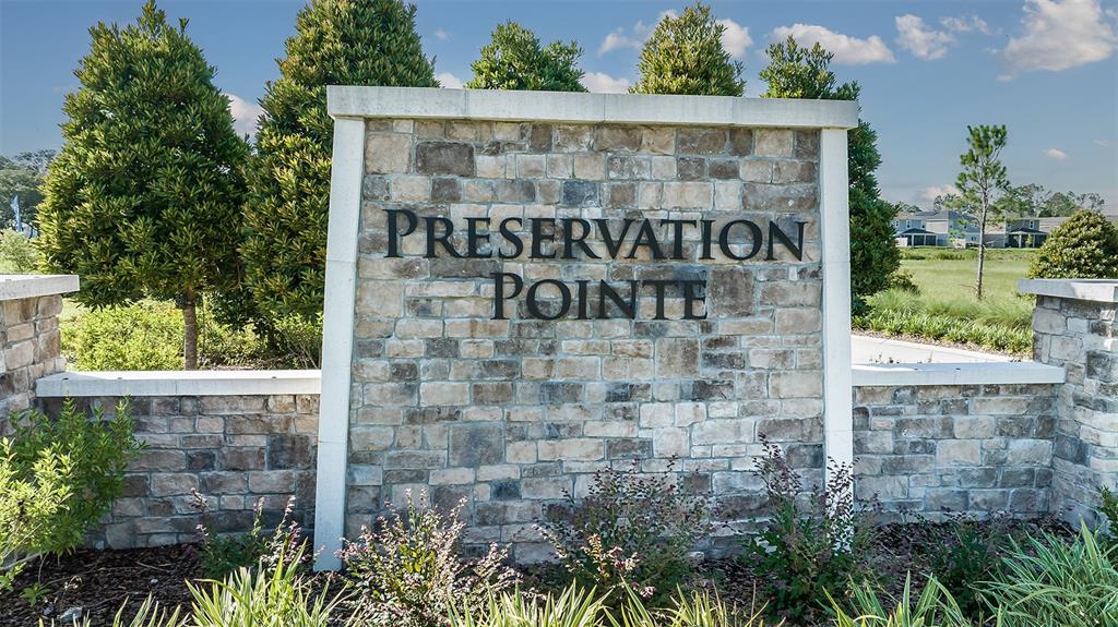 A stone monument sign with the text Preservation Pointe stands in front of landscaped greenery — 1329 SAWGRASS HAMMOCK LANE, DAVENPORT, FL