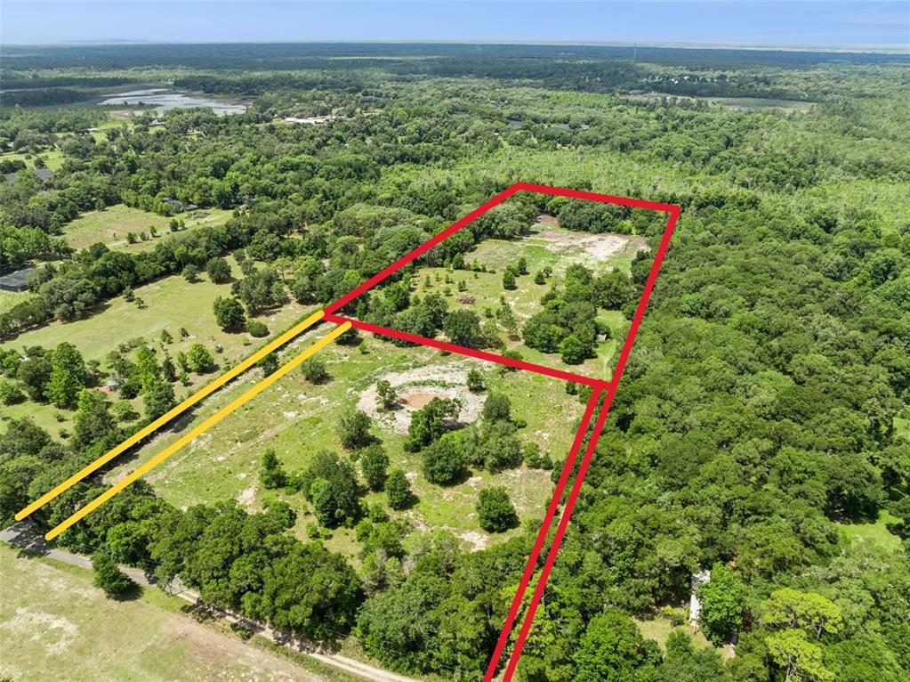 An aerial view shows a large, rectangular plot of land outlined in red — 2040 HOLLY HAMMOCK ROAD, DE LEON SPRINGS, FL