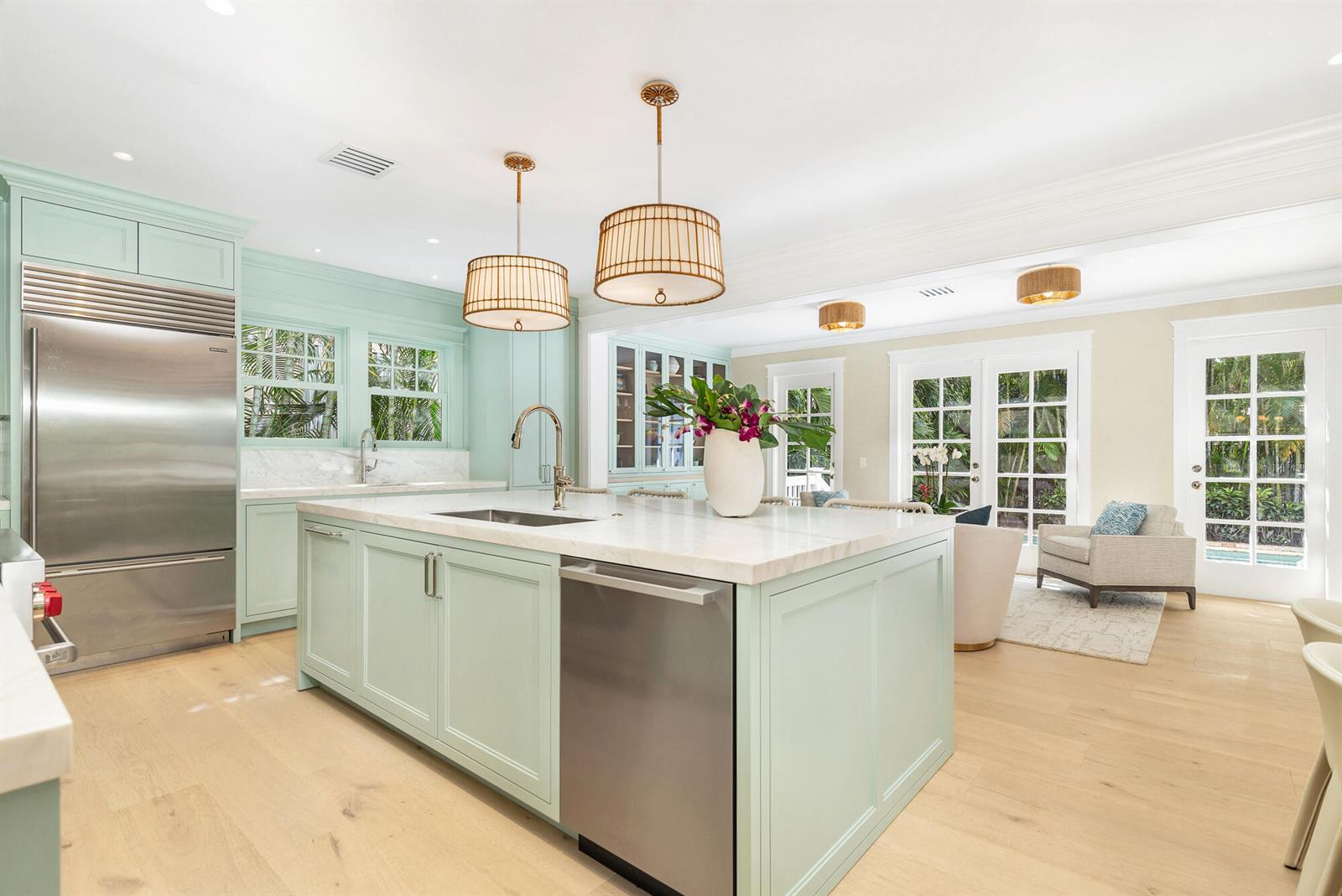 A kitchen features light green cabinetry, a marble-topped island, and stainless steel appliances — 142 Seabreeze Avenue, Palm Beach FL 33480, PALM BEACH, FL