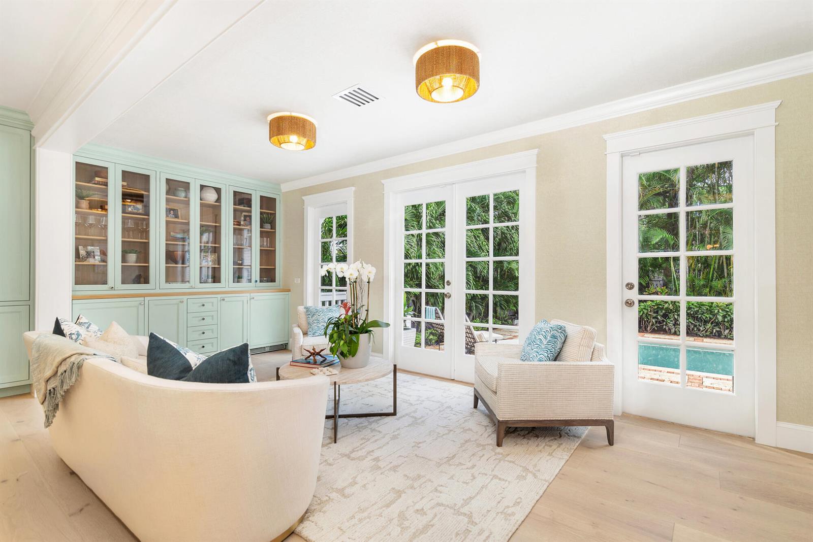 A living room features light green built-in cabinets, two woven ceiling lights, and French doors — 142 Seabreeze Avenue, Palm Beach FL 33480, PALM BEACH, FL