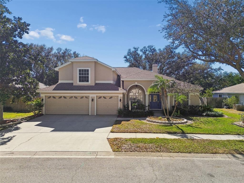 A two-story house with a three-car garage, arched entryway, and a blue front door — 928 OAKVIEW ROAD, TARPON SPRINGS, FL