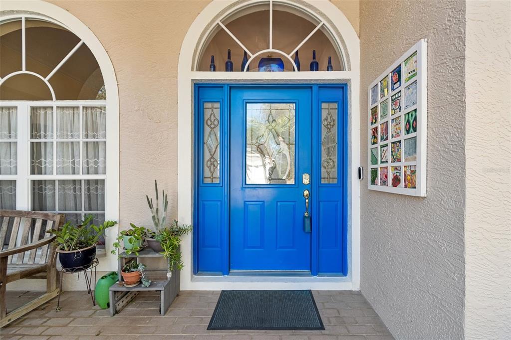 A bright blue front door with sidelights and a transom window sits on a porch — 928 OAKVIEW ROAD, TARPON SPRINGS, FL