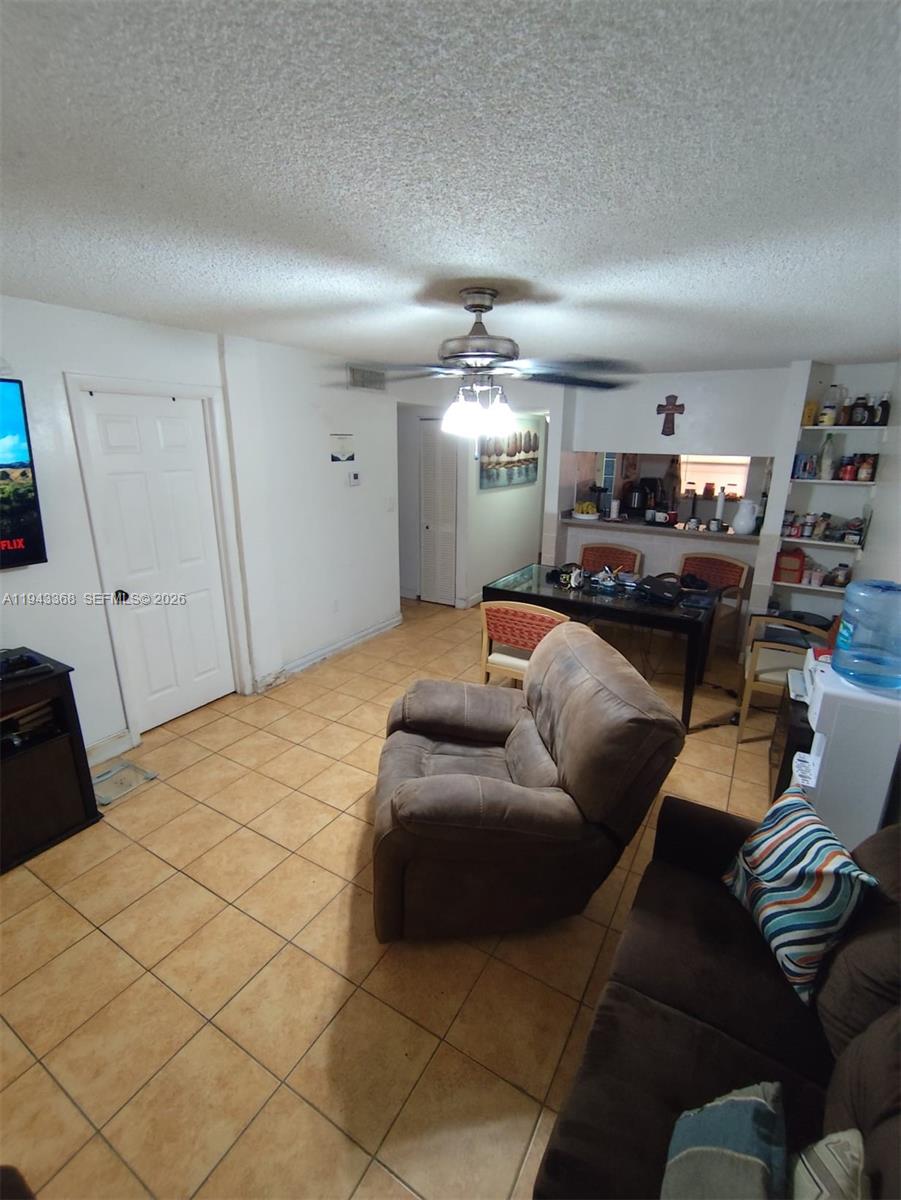 A living room with tile flooring, a ceiling fan, and an adjacent dining area — 19781 SW 114th Ave # 142, Miami FL 33157, MIAMI, FL