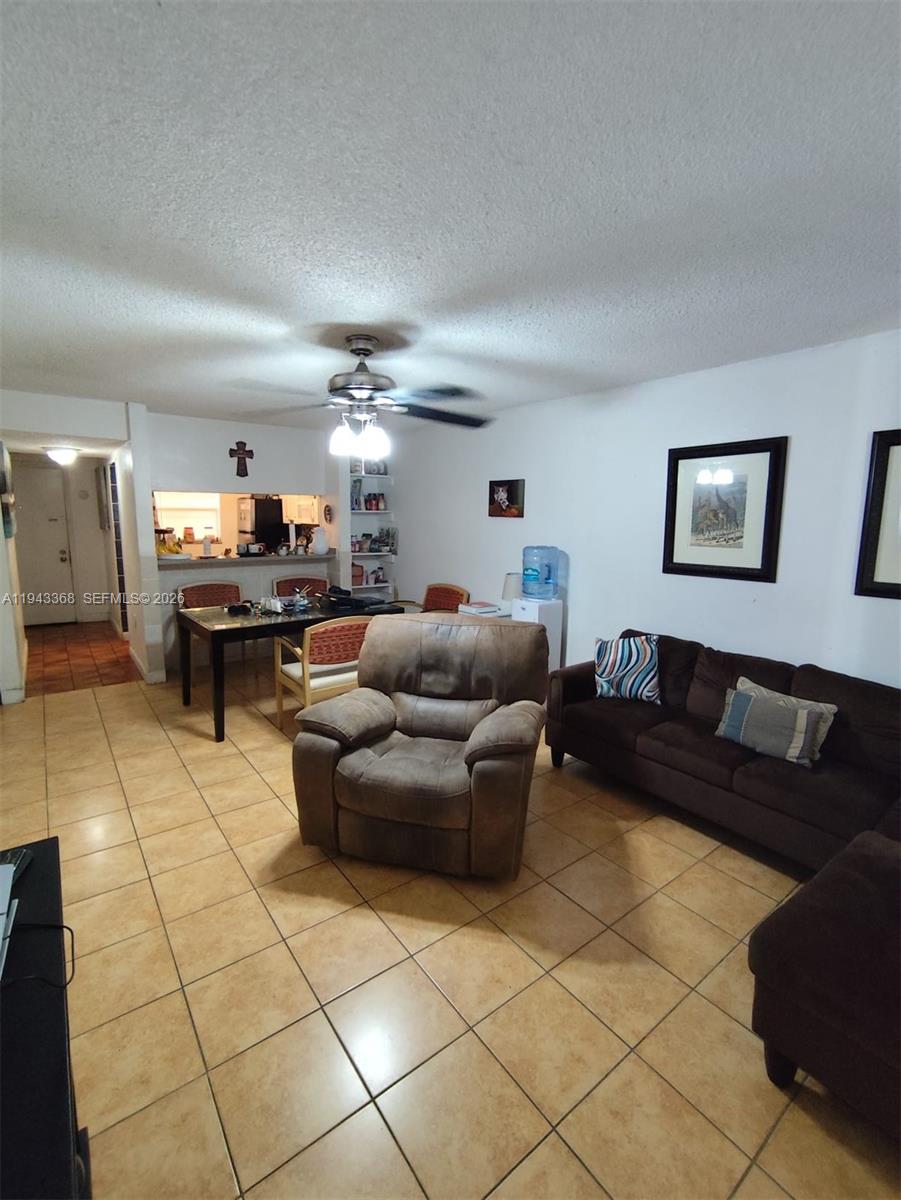 A living room and dining area feature tile flooring, a ceiling fan, and brown furniture — 19781 SW 114th Ave # 142, Miami FL 33157, MIAMI, FL