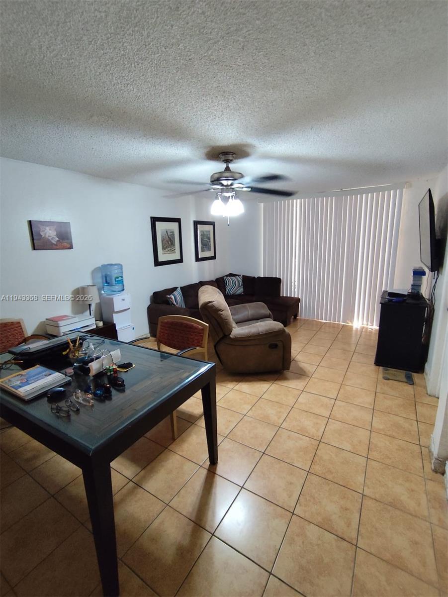 This living and dining area features tile flooring, a ceiling fan, and vertical window blinds — 19781 SW 114th Ave # 142, Miami FL 33157, MIAMI, FL