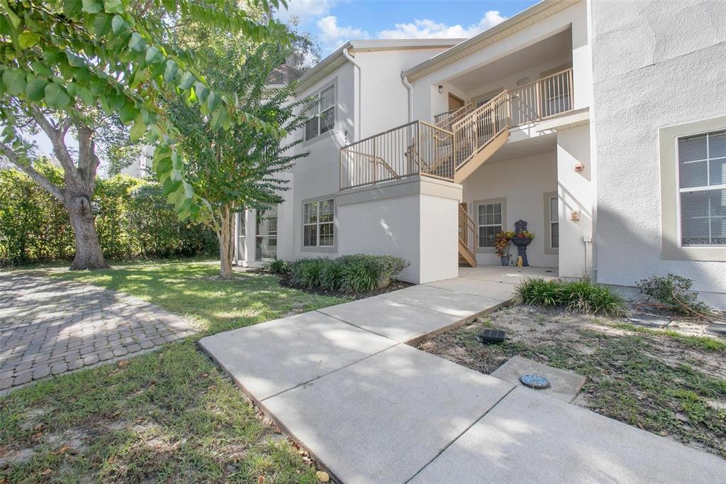 A two-story apartment building with a paved parking lot and a large tree in front — 970 N SPRING GARDEN AVENUE UNIT 311, DELAND, FL