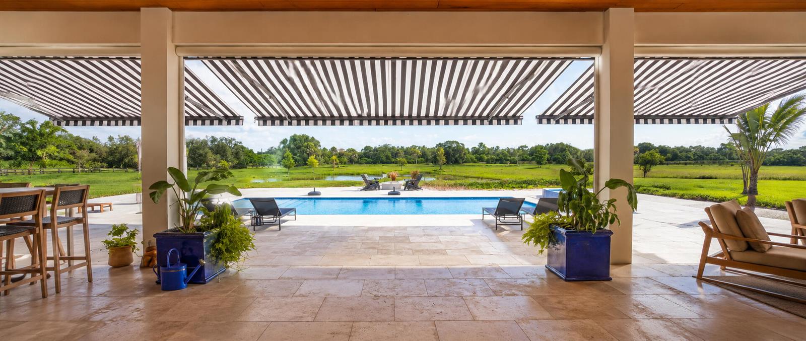A rectangular swimming pool with a spa and lounge chairs on a stone patio outdoors — 26209 SW Jockeys Run, Okeechobee FL 34974, OKEECHOBEE, FL