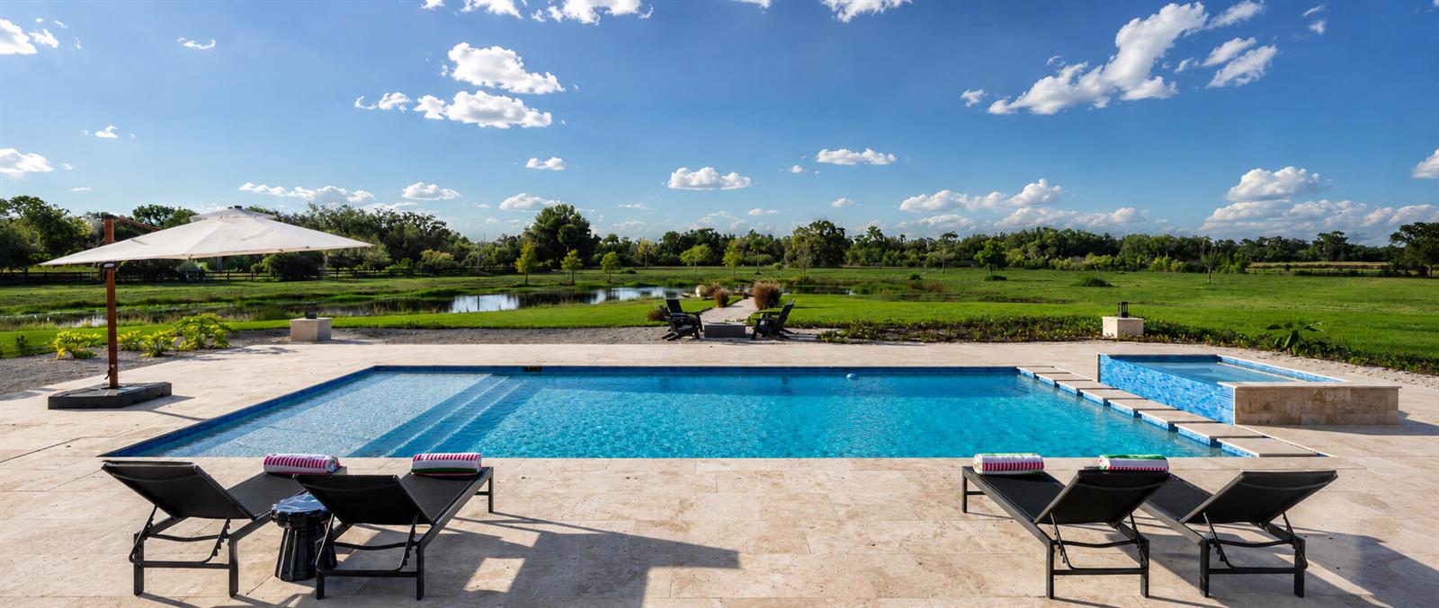 A spacious dining and living area features a large antler chandelier, stone fireplace, and rug — 26209 SW Jockeys Run, Okeechobee FL 34974, OKEECHOBEE, FL