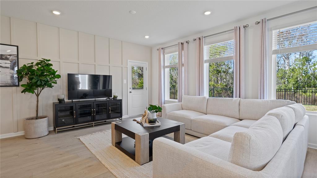 A living room features a light-colored sectional sofa, a dark coffee table, and board-and-batten walls — 5215 HAVEN VIEW DRIVE, CLERMONT, FL