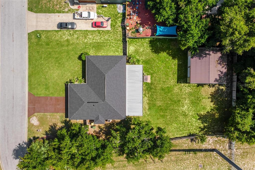 An aerial view shows a house with a dark roof, a backyard, and a detached shed — 200 WATERS EDGE DRIVE, LEESBURG, FL