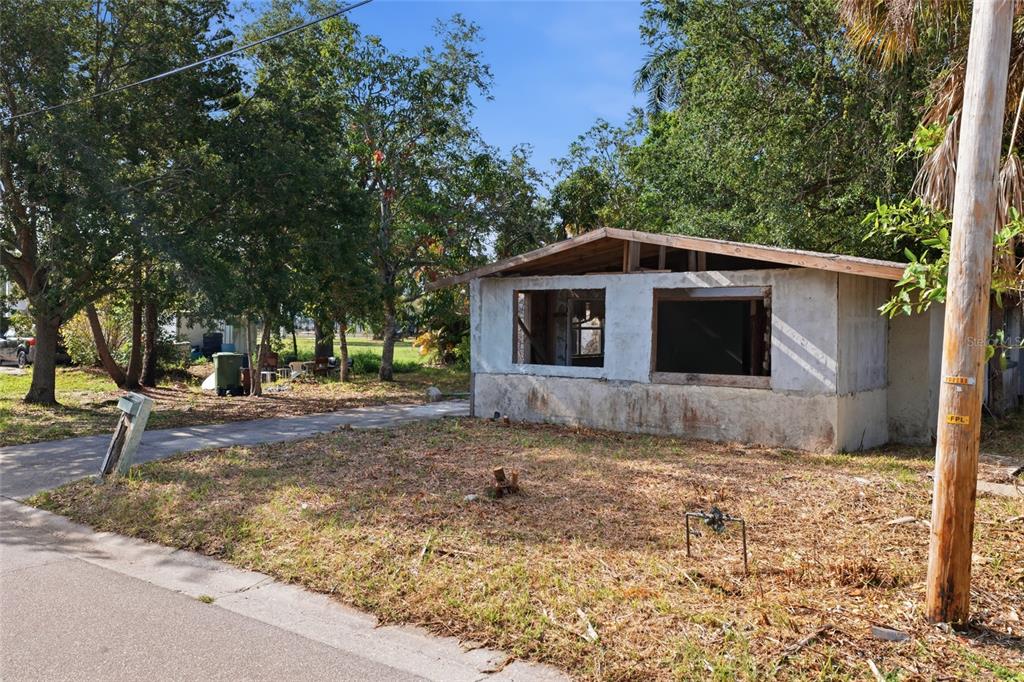 A small, dilapidated single-story structure with missing windows stands on a grassy lot — 202 12TH AVENUE E, BRADENTON, FL