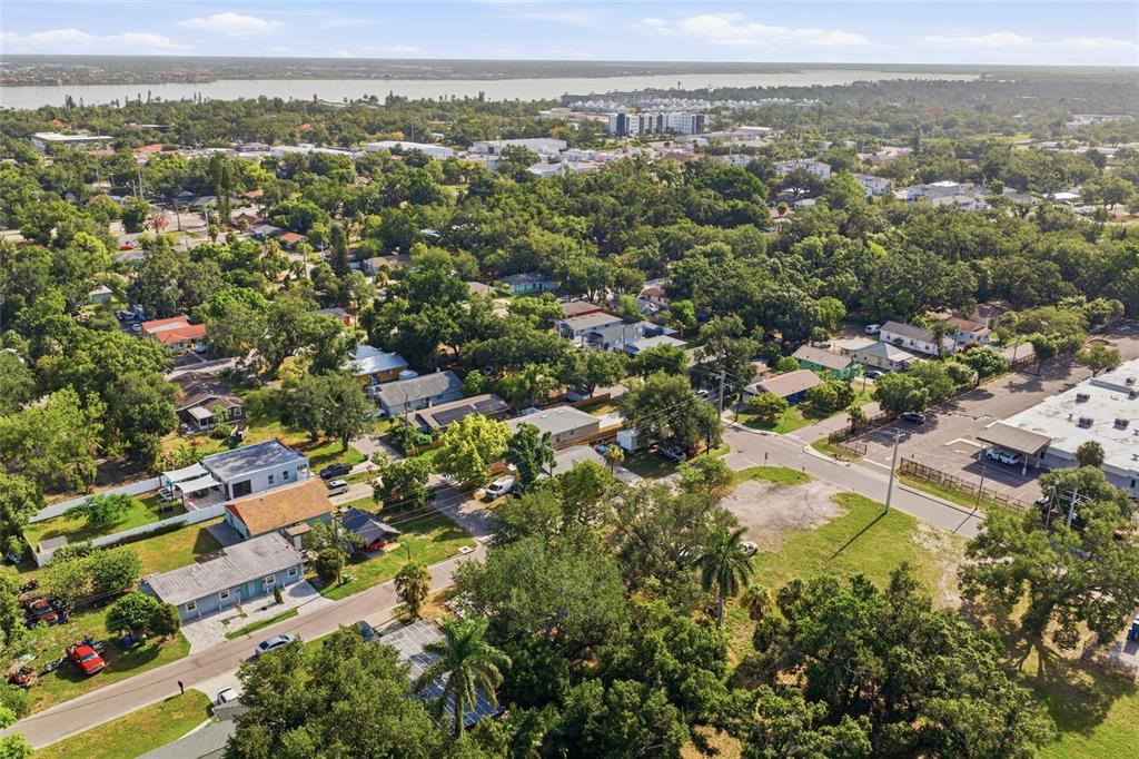 An aerial view shows a residential neighborhood with houses, trees, and a nearby body of water — 202 12TH AVENUE E, BRADENTON, FL