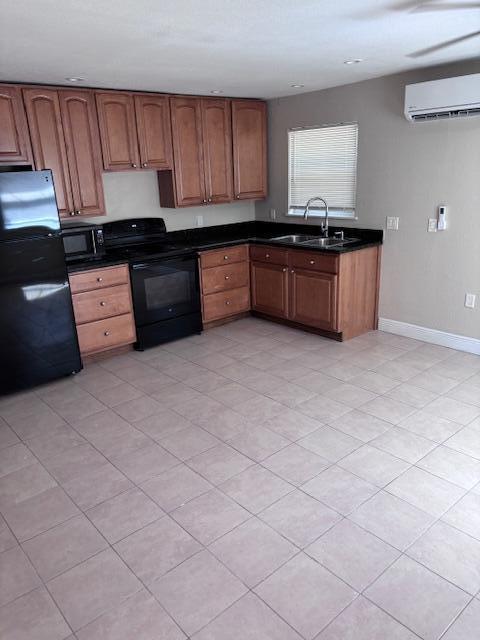 A kitchen features wooden cabinets, black appliances, and light-colored tile flooring — 5393 SE 48th Avenue Unit C, Stuart FL 34997, STUART, FL