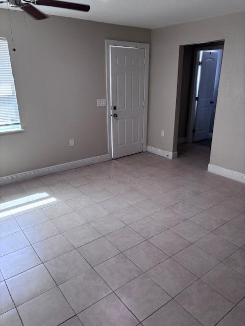 An empty room features light-colored tile flooring, a white door, and a ceiling fan — 5393 SE 48th Avenue Unit C, Stuart FL 34997, STUART, FL