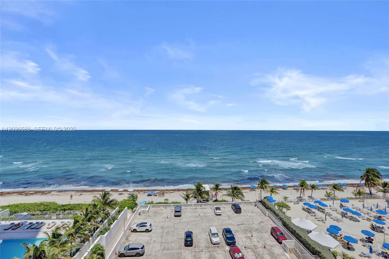 An elevated view shows a parking lot, beach, and the ocean under a blue sky — 2030 S Ocean Dr # 821, Hallandale Beach FL 33009, HALLANDALE BEACH, FL