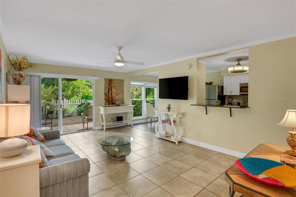 A living room with tile floors, a ceiling fan, and a sliding door to a patio — 3413 CLARK ROAD UNIT 114, SARASOTA, FL