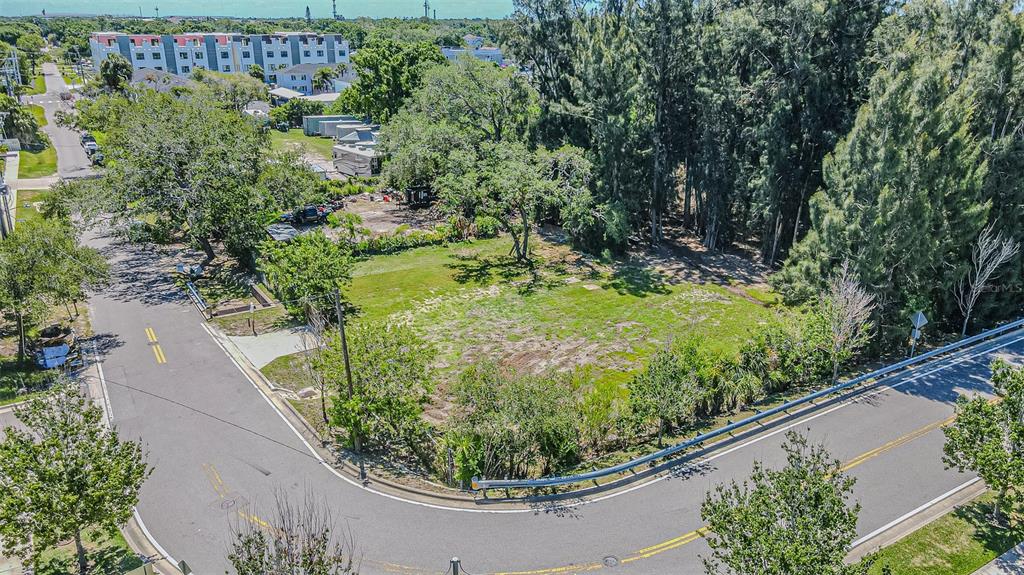An aerial view shows a vacant, grassy corner lot bordered by two paved roads — 4904 W PAUL AVENUE, TAMPA, FL