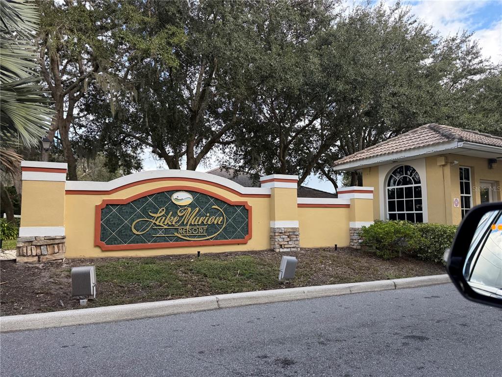A yellow stucco entrance sign for Lake Marion Resort stands beside a guardhouse — 353 PORT PLEASANT DRIVE UNIT 353, KISSIMMEE, FL