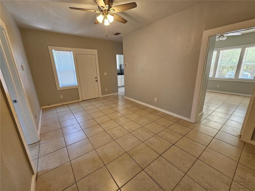 A room with beige tile flooring, a ceiling fan, and a doorway leading to another room — 1408 N FORT HARRISON AVENUE UNIT B, CLEARWATER, FL