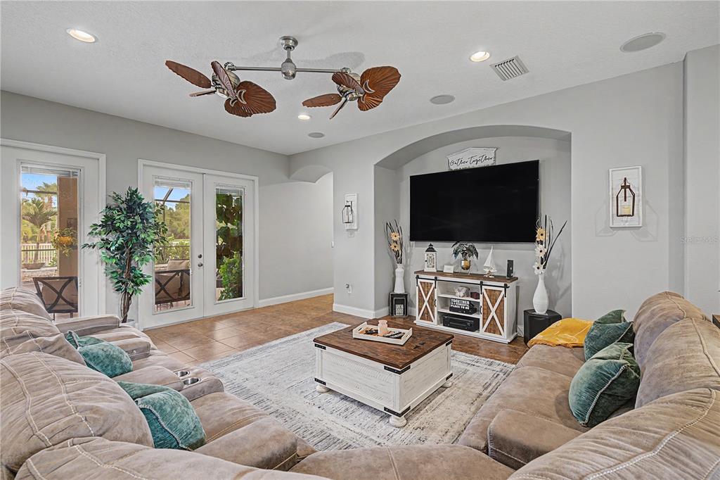 A living room features a large sectional sofa, a coffee table, and a wall-mounted television — 3038 MARBLE CREST DRIVE, LAND O LAKES, FL
