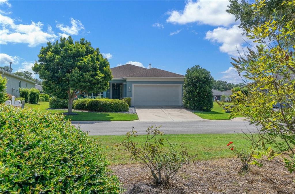 A single-story house with a two-car garage, a blue exterior, and a landscaped front yard — 8213 SW 78TH TERRACE ROAD, OCALA, FL
