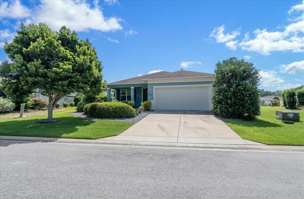 A single-story house with a blue exterior, a two-car garage, and a landscaped front yard — 8213 SW 78TH TERRACE ROAD, OCALA, FL