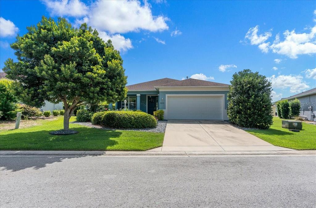 A single-story house with a two-car garage, a paved driveway, and a large front tree — 8213 SW 78TH TERRACE ROAD, OCALA, FL