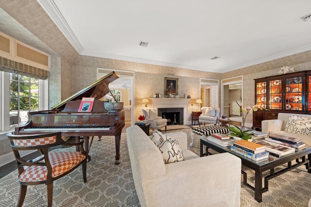 A living room features a grand piano, a fireplace, and a large wooden display cabinet — 100 SARASOTA ROAD, BELLEAIR, FL