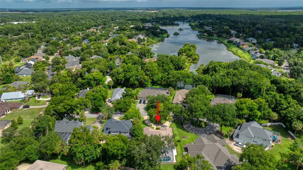 An aerial view shows a residential neighborhood with a red arrow pointing to a house — 5 WATERCLIFF LANE, ORMOND BEACH, FL