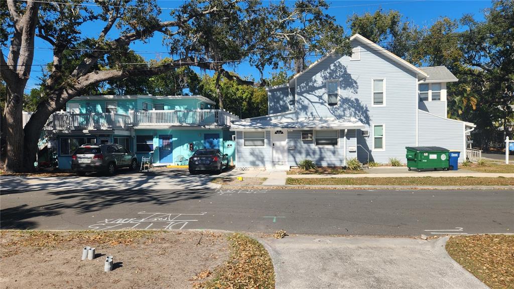 A two-story light blue house sits next to a smaller turquoise building with a balcony — 614 OAK AVENUE, CLEARWATER, FL
